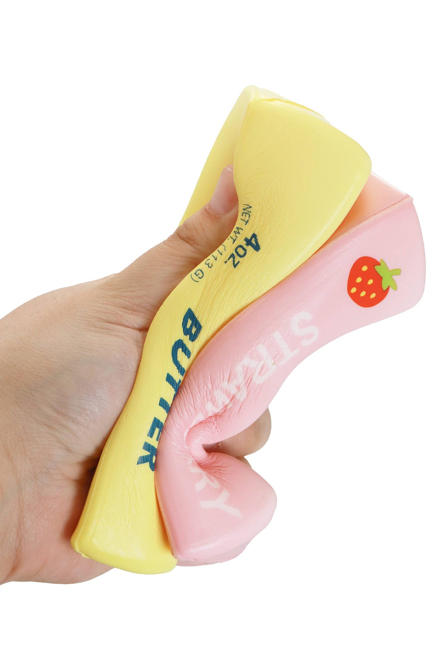5-inch butter-scented slow-rising foam squishy, yellow and pink with strawberry graphic, being squeezed by hand.