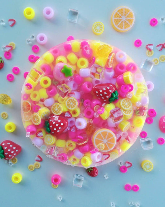Berry Lemonade Picking Pad fidget toy with pink and yellow beads, fruity charms and lemon slices.