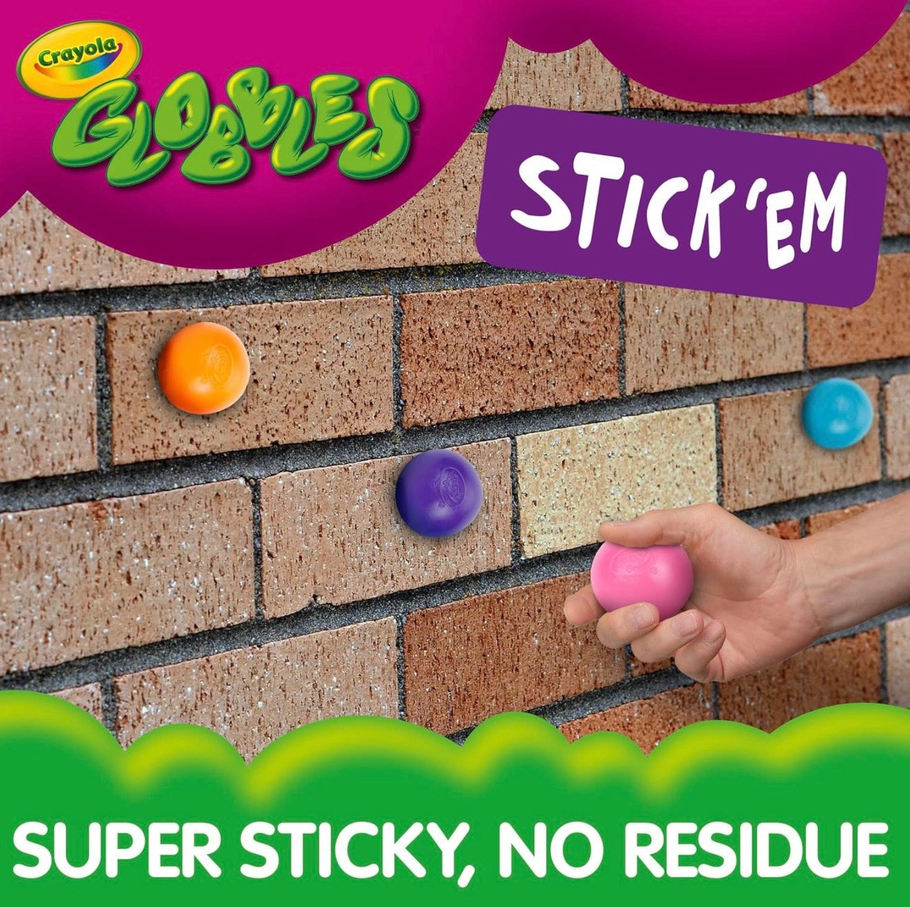 Le Sage May Crayola Globbles sensory balls sticking to a brick wall, demonstrating their squishy and sticky design.