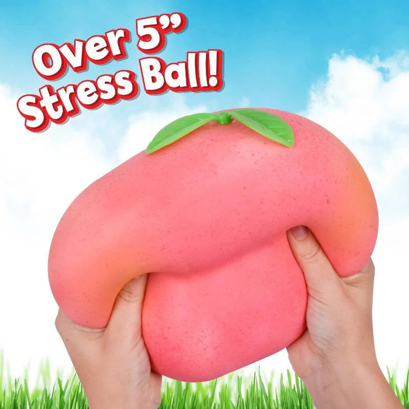 Le Sage May jumbo peach-shaped sensory stress ball being squeezed by hands against a blue sky background.
